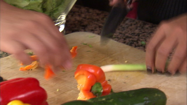 Tilt up shot of a couple preparing a salad.