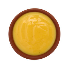 Bowl of honey mustard dressing on a white background
