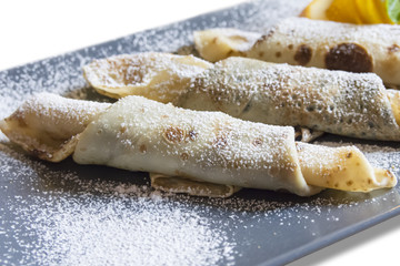 Delicious pancakes with powdered sugar on a white background