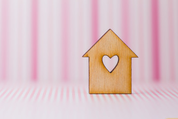 Obraz na płótnie Canvas Wooden house with hole in the form of heart on pink striped back