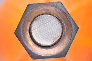 Closeup nut and bolt with selective focus on orange background