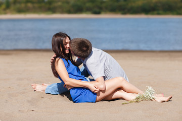 A young couple walks along the beach.