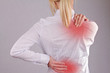 Woman with neck / back pain. Business woman rubbing her painful back close up. Pain relief concept