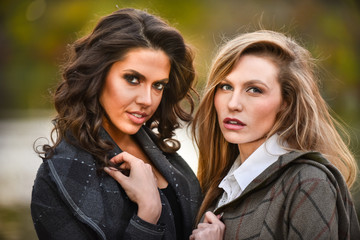 Two beautiful girls against an autumn nature background.