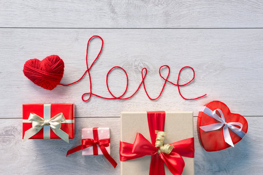 Red heart, Word "Love" and Valentines Day gifts boxes on wooden background. Valentines Day background