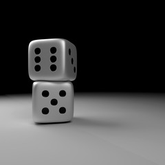 two silver dice over dark