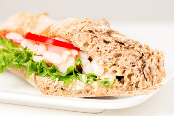 Prawn sandwich on white plate close up
