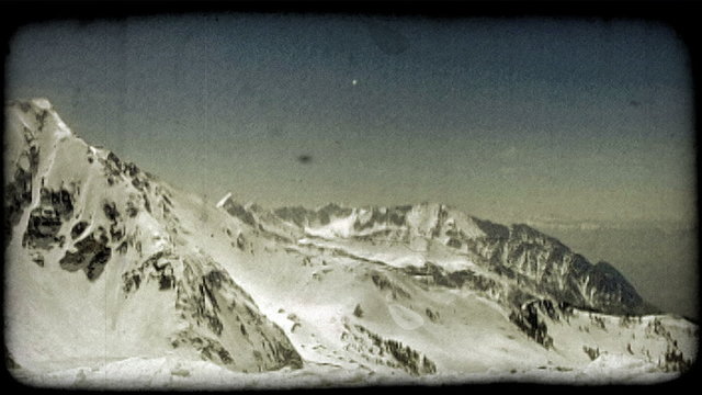 Skier skis off snow ledge. Vintage stylized video clip.