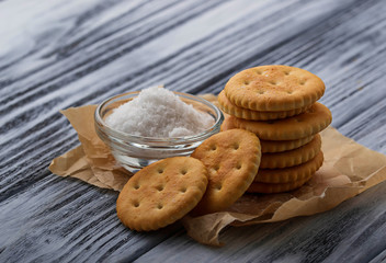 Salty cracker and salt on wooden background