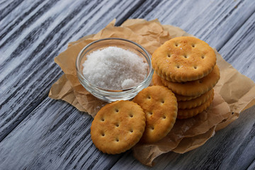 Salty cracker and salt on wooden background