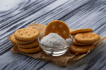 Salty cracker and salt on wooden background