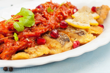 Pieces of fried fish with vegetable sauce.