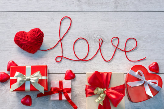 Red heart, Word "Love" and Valentines Day gifts boxes on wooden background. Valentines Day background