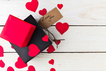 Gift boxes and heart papercut on wooden background