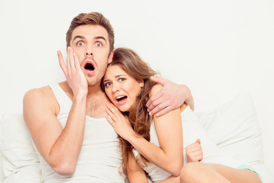 Scared young beautiful couple at home watching a movie