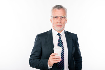 Aged handsome man with glasses in a black suit holding a cup of