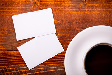 Obraz na płótnie Canvas White coffee cup with business card on table