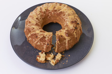 cake with raisins on dark ceramic plate separated over white background
