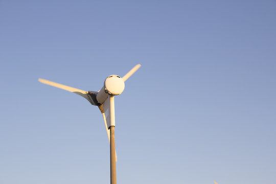 Small wind turbine of the size which would be used to power a particular building , business or some location rather than as part of a large wind farm. Viewed from the rear.