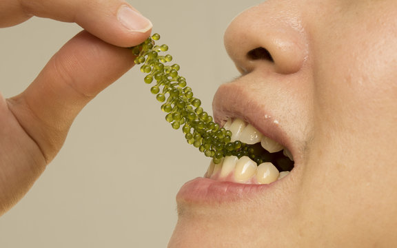 female eating healthy green seaweed snack