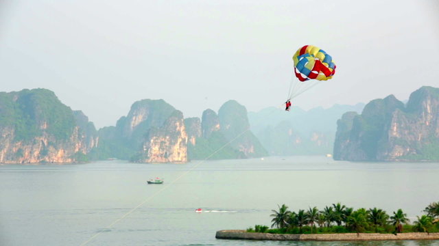 parasailing over limestone mountain islands, Halong Bay, Vietnam