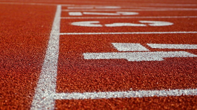 Track runner putting his hands at starting line