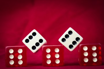 A set of die all showing sixes against red felt
