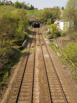 Railway track in England. Double track entering a short tunnel near Walsden, West Yorkshire on the Manchester-Todmorden-Hebden Bridge line. At the far end of the tunnel Walsden station is just visible