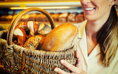 Bäcker Frau mit Brotkorb in Bäckerei verkauft Brot