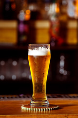 Closeup image of glass with golden unbottled light beer at bar 