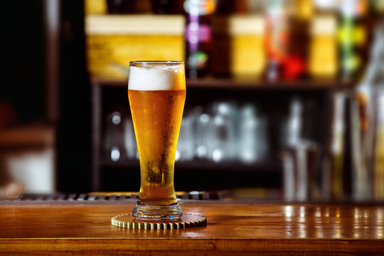 Closeup image of glass with golden unbottled light beer at bar 