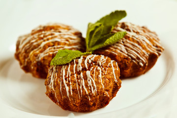 Closeup image of tasty brown muffins decorated with fresh mint 