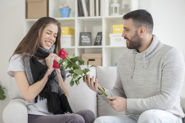 Young man gives a girl flowers for Valentine's Day, shallow depth of field