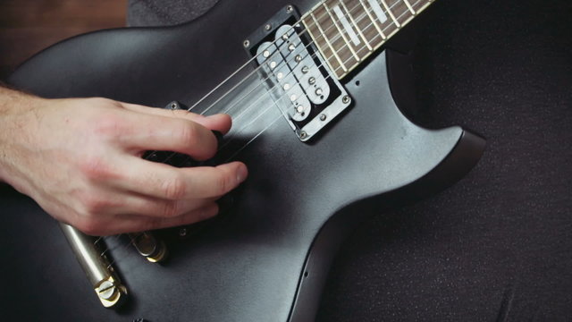 close up man playing the electric guitar slow motion