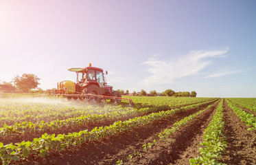 Farmer spraying soybean field with pesticides and herbicides