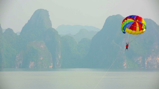 parasailing over limestone mountain islands, Halong Bay, Vietnam