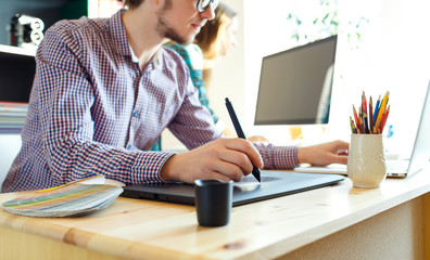 Artist drawing something on graphic tablet at the home office