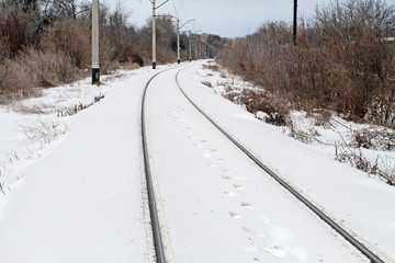 Obraz premium Traces of the person walking on the snowy railway. Next the whit