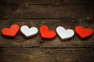 Red and white hearts on old shabby wooden background