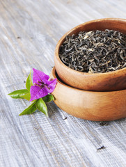 Green tea in a wooden bowl with flowers