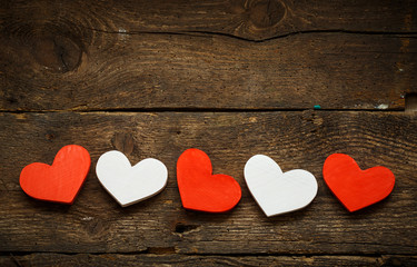 Red and white hearts on old shabby wooden background
