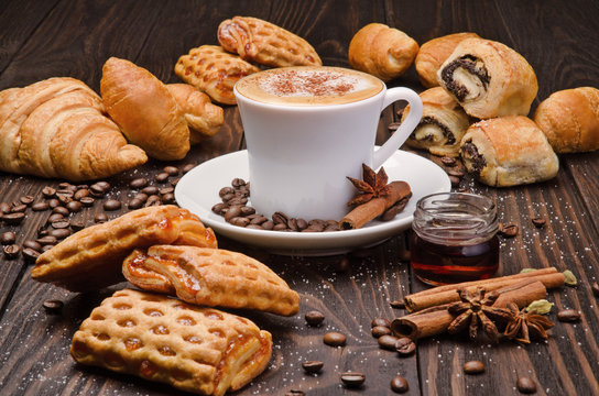 Cup of Coffee with Pastry on brown wood table background