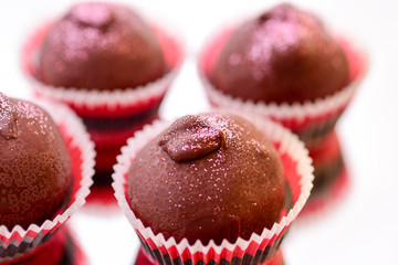 Chocolate Truffles on reflective surface with focus on foreground