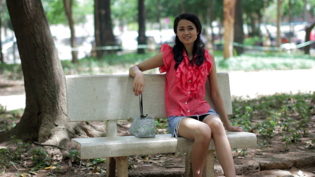 Asian girl sitting bank bench alone