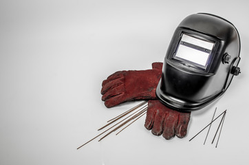 welding mask with red gloves and tungsten rods