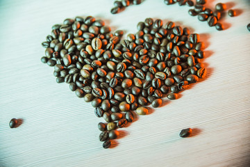 closeup a sign of heart made of coffee beans in evening blue tones