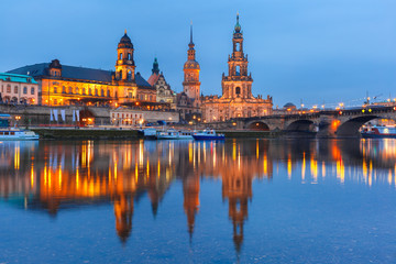 Fototapeta premium Dresden Cathedral of the Holy Trinity aka Hofkirche Kathedrale Sanctissima Trinitatis, Bruehl's Terrace aka The Balcony of Europe and Augustus Bridge with reflections in the river Elbe at night in
