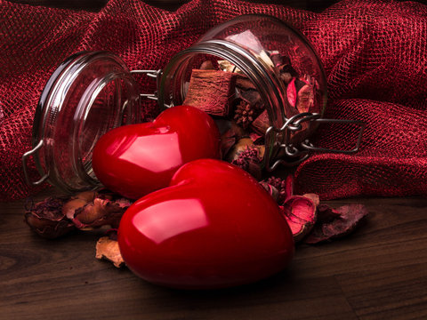 two hearts with jar of essences on wooden table