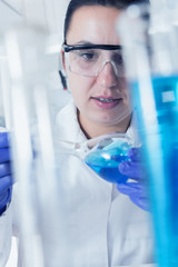 Young Female Scientist Analyzing Sample In Laboratory.laboratory assistant analyzing a sample.