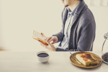 朝食を食べながら仕事をしている日本人男性